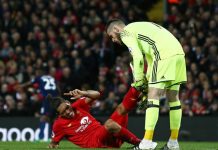 Manchester Utd:s målvakt hjälper Liverpoolspelare på traven.