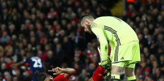 Manchester Utd:s målvakt hjälper Liverpoolspelare på traven.